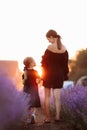 happy family concept. young mother with child daughter are walking in lavender field in sunset light. mom and child girl Royalty Free Stock Photo