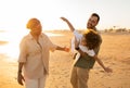 Happy family concept. Young mother, father and their son having fun on the beach parents fooling with kid in the evening Royalty Free Stock Photo
