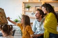 Happy family concept. Young parents with children painting together at home. People fun happyiness.