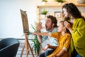 Happy family concept. Young parents with children painting together at home. People fun happyiness.