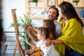 Happy family concept. Young parents with children painting together at home. People fun happyiness.