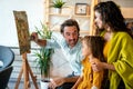 Happy family concept. Young parents with children painting together at home. People fun happyiness.