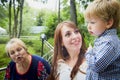 Happy family consisting senior lady grandmother, young mother and small son in garden or park in a summer or autumn