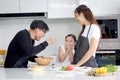 Happy family cooking at kitchen, father mother and cute daughter girl having fun during making meal at home. Parents and kid child Royalty Free Stock Photo