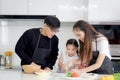 Happy family cooking at kitchen, father mother and cute daughter girl having fun during making meal at home. Parents and kid child Royalty Free Stock Photo