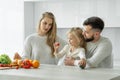 Happy family cooking together in the kitchen. A pregnant mother shows her little daughter vegetables and fruits. Home Royalty Free Stock Photo