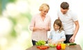 Happy family cooking vegetable salad for dinner