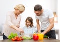 Happy family cooking vegetable salad for dinner