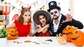 Happy family in costumes getting ready for halloween at home Royalty Free Stock Photo