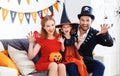 Happy family in costumes getting ready for halloween at home