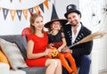 Happy family in costumes getting ready for halloween at home Royalty Free Stock Photo