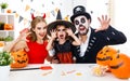 Happy family in costumes getting ready for halloween at home Royalty Free Stock Photo