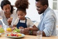Happy family couple and daughter girl preparing salad in kitchen Royalty Free Stock Photo