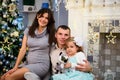 Happy family couple give gifts in the living room, behind the decorated Christmas tree, the light give a cozy atmosphere Royalty Free Stock Photo