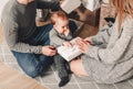 Happy family couple give gifts in the living room, behind the decorated xmas tree, the light give a cozy atmosphere. New Year Royalty Free Stock Photo