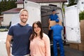 Happy Family Couple And Movers Unload Boxes Royalty Free Stock Photo