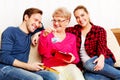 Happy family - couple with old woman who holding gift box and baby shoe Royalty Free Stock Photo