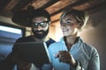 Happy family couple using electronic tablet in livingroom at home.Bearded man in eye glasses making conversation with Royalty Free Stock Photo