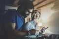 Happy family couple using electronic tablet in livingroom at home. Bearded man in eye glasses making conversation with Royalty Free Stock Photo