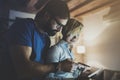 Happy family couple using electronic tablet in livingroom at home.Bearded man in eye glasses making conversation with Royalty Free Stock Photo