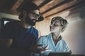 Happy family couple using electronic tablet in livingroom at home.Bearded man in eye glasses making conversation with Royalty Free Stock Photo