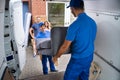 Happy Family Couple Watching Movers Unload Furniture