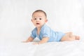 Happy family, Cute Asian newborn baby wear blue shirt lying, crawling, play on white bed Royalty Free Stock Photo