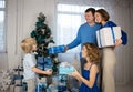 happy family, dad, mom, adult children on the background of a decorated Christmas tree exchange gifts Royalty Free Stock Photo