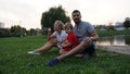 Happy family - dad, mom and little son sitting on grass in the park in summer Royalty Free Stock Photo