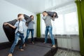 Happy family, Dad, Mom and son spend time together, fooling around on the bed, beating with pillows. Concept of happy father`s da Royalty Free Stock Photo