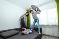 Happy family, Dad, Mom and son spend time together, fooling around on the bed, beating with pillows. Concept of happy father`s da Royalty Free Stock Photo