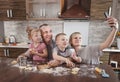 happy family dad mom and two kids take selfies in the kitchen while making cookies. cooking together happy family