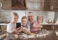 happy family dad mom and two kids take selfies in the kitchen while making cookies. cooking together happy family