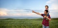 happy family dad with son on his shoulders walk at sunset. Time with your family in nature. Father showing his son the