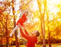 Happy family Dad throws child daughter up on walk in autumn Royalty Free Stock Photo