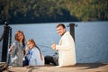 Happy family with daughter fishing in pond in fall Royalty Free Stock Photo