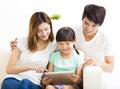 Happy family and daughter using tablet on sofa Royalty Free Stock Photo