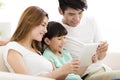 Happy family and daughter watching tablet on sofa Royalty Free Stock Photo