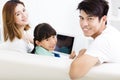 Happy family and daughter watching tablet on sofa Royalty Free Stock Photo