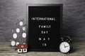 Happy Family Day. Black letter board with text, clock, house model and photo frame on wooden table Royalty Free Stock Photo