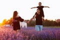 happy family day. Young mother and father carrying on shoulders daughter in lavender field on sunset. Dad, mom and child Royalty Free Stock Photo