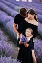 happy family day. Young mother, father and little daughter in purple lavender field. Dad, mom and child hugging and Royalty Free Stock Photo