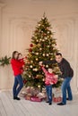 Happy family decorate the Christmas tree indoors together. Loving family. Merry Christmas and Happy Holidays