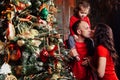 Happy family decorating a Christmas tree with boubles in the living-room.