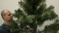 Happy family decorating a Christmas tree with boubles in the living-room