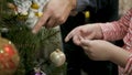 Happy family decorating a Christmas tree with boubles in the living-room