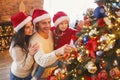 Happy family decorating Christmas tree with bubbles in living room