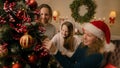 Happy family decorating Christmas tree with toys Royalty Free Stock Photo
