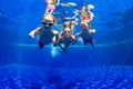 Happy family dive underwater in swimming pool