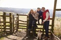 Happy family with dog by a gate in the countryside Royalty Free Stock Photo